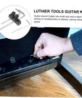 Hand using Guitar Wrench Holder For Headstock Key Storage with metal mount showing easy install tremolo maintenance tool on wood surface.