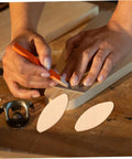 Hands marking wood with pencil and 100 Pcs Wood Joiner Biscuits Set for Woodworking Projects nearby.