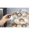 Hand selecting a coffee pod from the K-Cup Pod Carousel Organizer for Home and Office, Chrome 40-Pod Lazy Susan With 360-Degree Spin