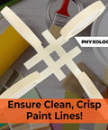 Pro Grade 3/4 Inch Masking Tape, 60 Yard Rolls, 12 Pack crossed on a table with painting supplies and brushes.