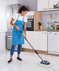 Woman using Heavy Duty Cotton Wedge Dust Mop Head For Hardwood Floors And Commercial Janitorial Use for cleaning a kitchen floor.