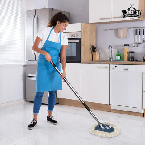 Woman using Heavy Duty Cotton Wedge Dust Mop Head For Hardwood Floors And Commercial Janitorial Use for cleaning a kitchen floor.
