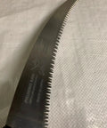 Close-up of Samurai Ichigeki 13 Inch Pruning Saw with Japanese blade, showing sharp TRI CUT teeth and part of the handle.