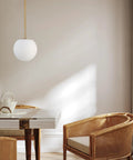 Mid Century Modern 1 Light Pendant Light With White Glass Globe Shade And Gold Finish Brushed Brass Fixture in dining area