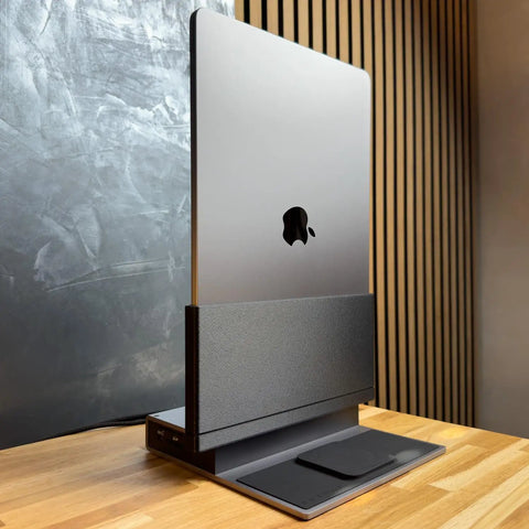 Dead Simple Vertical Thunderbolt 4 MacBook Docking Station Driving Two 4K Displays At 60Hz With Twelve Rock Solid Ports And Hella Fast 96 Watt Charging Plus Magsafe positioned vertically on a wooden desk.