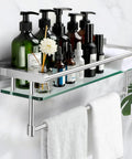 Brushed Nickel 20 Inch Glass Bathroom Shelf With Towel Bar displayed with toiletries, mounted on wall with white towels hanging below