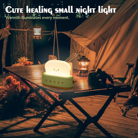 Rechargeable Cute Toaster Lamp With Smile Face on an outdoor table, glowing softly at night, cozy ambiance for any room.