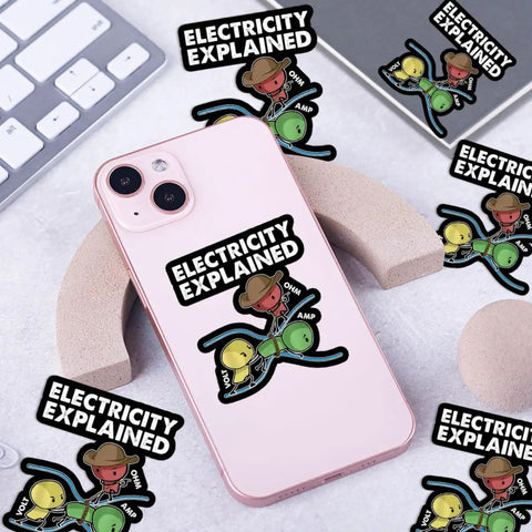 Three Piece Electricity Explained Sticker Set With Funny Volts Amps Ohms Quotes For Electrical Engineers Physics Teachers And STEM Students displayed with phone and keyboard