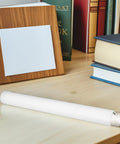 White Plastic Mailing Tubes With Caps 4 Pack 3.5x31 Cm Straight Tubes on a desk beside books and a wooden frame
