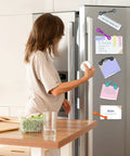 Woman using Magnetic Cable Clips Set Of 12 for Cable Management and Organization as whiteboard and fridge magnets.