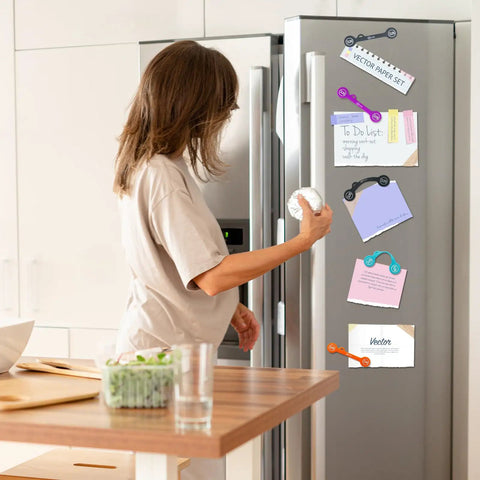 Woman using Magnetic Cable Clips Set Of 12 for Cable Management and Organization as whiteboard and fridge magnets.