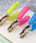 12 Piece Multicolor Single Hole Puncher Set, Quarter Inch Metal Handheld Circle Punch With Soft Grip displayed on notebook
