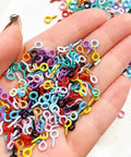Colorful Screw Eye Pins in hand showcasing solid metal build, mixed sizes ideal for DIY Jewelry Crafter projects.