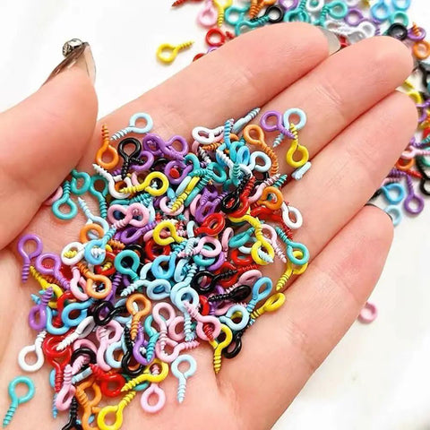 Colorful Screw Eye Pins in hand showcasing solid metal build, mixed sizes ideal for DIY Jewelry Crafter projects.