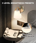 Battery Operated Wall Sconce With Glass Shade, 3000K Warm White, mounted by a bed with a dimmable touch switch in use.