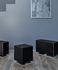 Three black OSKAR Evaporative Humidifiers on a wooden floor in a modern gray room setting