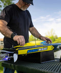Man preparing Sonicwake RC Boat 48 Inch Self Righting Brushless 8S Ready To Run with Spektrum Smart Electronics on table.