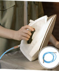 Person using high temperature steam hose for ironing, flexible lightweight water line tube, heavy duty pressure resistant ironing connection.