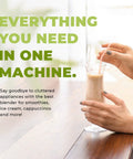 Creamy smoothie in a glass, held by hands on a wooden table, promoting Beast Pro Grade Countertop Blender With 3 HP 1800W Motor 64 Oz Jar Stainless Steel Blades Heavy Duty Commercial Kitchen Blender For Ice Crushing Smoothies Sauces And Hot Or Cold Blending 5 Year Warranty.