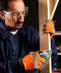 Man using Black And Decker Mouse Sanding Pads Pack With 60 80 120 150 220 Grits on wooden plank, workshop setting.