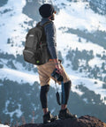 Hiker wearing 40L Lightweight Packable Hiking Backpack With Wet Pocket Waterproof Daypack For Travel Camping And Outdoor Adventures Durable And Easy To Carry For Rainy Trails in snowy mountains