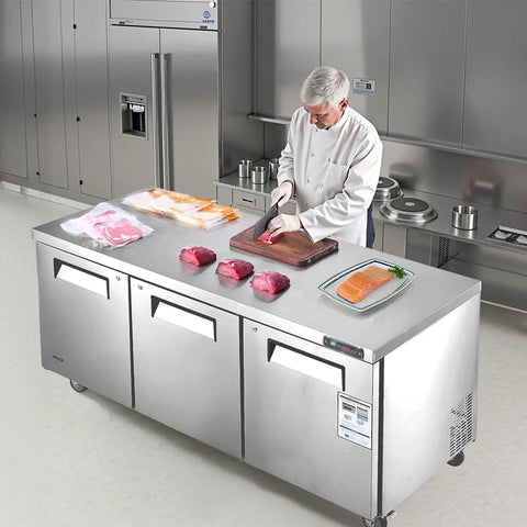 Tough 72 Inch Wide Commercial Undercounter Freezer With Triple Locking Doors And Smooth Rolling Casters, 17 Point 7 Cu Ft Stainless Steel Prep Worktable used in a restaurant kitchen.