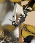 Close-up of HVAC Flex Duct Cable Tie Tensioning Tool With Auto Cut Off used on duct, showing adjustable tension knob in action