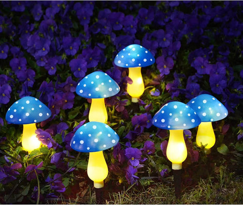 Six Pack Blue Solar Garden Mushroom Stake Lights With Eight Lighting Modes For Outdoor Yard Decor glowing among purple flowers.