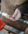 Person using Pen Press Kit For Woodturning Lathes With MT1 Taper, showing dual nylon pads aligning a pen nib.