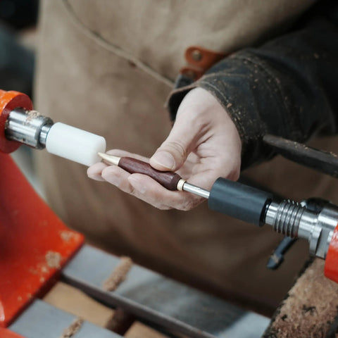 Person using Pen Press Kit For Woodturning Lathes With MT1 Taper, showing dual nylon pads aligning a pen nib.