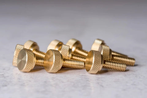 Top Shelf Brass Knurled Thumb Screws Ten Pack One Quarter Twenty Thread Three Quarter Inch Length Diagonal Grip on a surface.