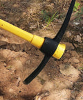 Close-up of Beast Mode Heavy Duty Forged Mattock with Adze digging into soil, showing ergonomic non-slip handle and sturdy design.