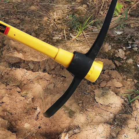 Close-up of Beast Mode Heavy Duty Forged Mattock with Adze digging into soil, showing ergonomic non-slip handle and sturdy design.