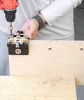 Heavy Duty Woodworking Doweling Jig Kit with Self Centering Anodized Aluminum Body and 6 8 10 mm Drill Bits plus 12mm Eccentric Wheel in use drilling into wood.