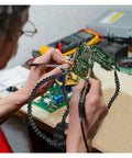 Third Hand Soldering Station with Adjustable Gooseneck Arms holds PCB for electronics repair, secure support shown.