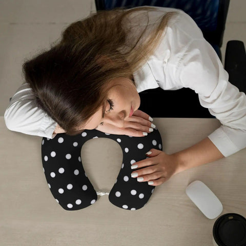Woman napping on desk with Polka Dot U Shaped Travel Pillow With Memory Foam Core For Naps On Planes Cars And At Home Or In The Office