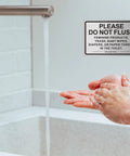 Two Pack Do Not Flush Sign For Bathroom Self Adhesive Aluminum Metal Sign With Brushed Aluminum Black Finish 9 By 6 Inches Perfect For Restrooms In Offices Restaurants And Homes displayed beside a faucet.