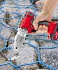 High Power 600W Electric Metal Shear With Two Speed Swivel Head Cordless Tin Snips For Cutting Stainless Steel Sheets And Thin Metal Includes Dual Batteries And Hardened Chrome Vanadium Steel Blade For Precision Jobs in use, cutting through blue netting over rocks.