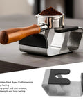 Heavy Duty Built Tough Stainless Steel Portafilter Stand And Espresso Tamper Station with wooden handle and coffee grounds.