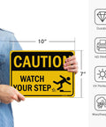 Person holding Watch Your Step Caution Sign 10 By 7 Inches Reflective Aluminum Safety Sign For Outdoor And Indoor Use