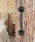 Four Pack Cast Iron Sliding Barn Door Handles 5.51 Inch Dark Brown Vintage Metal Pulls For Outdoor Fence Gate Cabinet Drawer Closet Garage Interior Built To Last Rust Resistant installed on wood door next to a bed