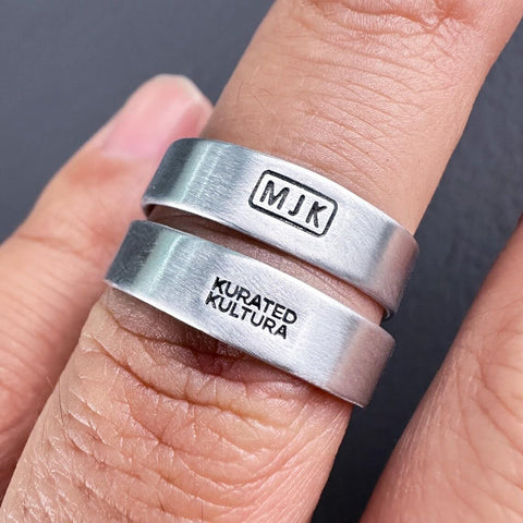 Pro Grade Metal Signature Stamp For Jewelry And Metalwork showing "MJK" and "KURATED KULTURA" imprints on silver rings.