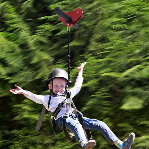 Child enjoying Backyard Zip Line Kit For Kids And Adults Up To 330 Lb, 120 Ft Stainless Steel Zip Line With Spring Brake and Helmet