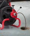 Heavy Duty Workhorse Electric Drain Auger Machine With Automatic Forward And Reverse Footswitch Control Plug And Play Badass Performance For Pro Plumbers One Hundred Feet By Three Eighths Inch Steel Cable Six Sharp Cutters at drain opening.