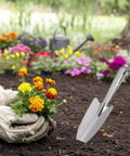 Gardener using Stainless Steel Garden Trowel And Hand Shovel With Pro Grade Measurement Marks For Planting Transplanting Weeding And Digging Durable Rust Resistant Garden Tool For Home Gardeners Ergonomic Grip Multi Purpose Spade in flower bed