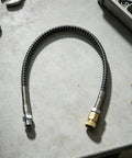 Heavy Duty Air Hose For Compressor Rock Solid Brass Lock Joints Hella Flexible Anti Kink Tubing High Pressure Pneumatic Line on workbench.