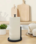 Stainless Steel Freestanding Paper Towel Holder For Countertop with black rack and anti-slip weighted base on wooden table.