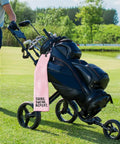 Swing Swear Repeat Embroidered Pink Golf Towel With Clip For Golf Bags on cart outdoors