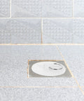 4pcs Rubber Bathtub Drain Stopper with Pull Ring installed in a gray tiled bathroom, showcasing its efficient sealing feature.