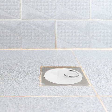 4pcs Rubber Drain Stoppers for Bathtubs and Floor Drains installed in a tiled bathroom floor drain.